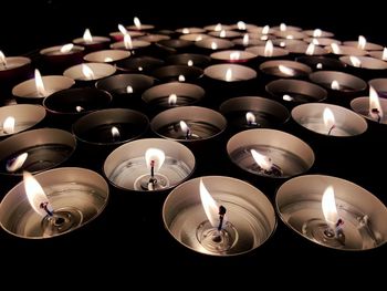 High angle view of lit candles in darkroom