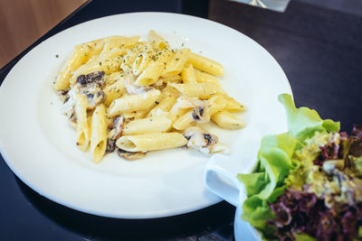 High angle view of mushroom creamy and rigatoni pasta served in plate