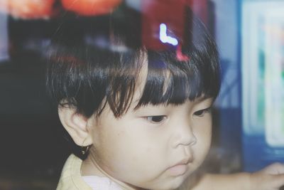 Close-up of baby girls seen through glass