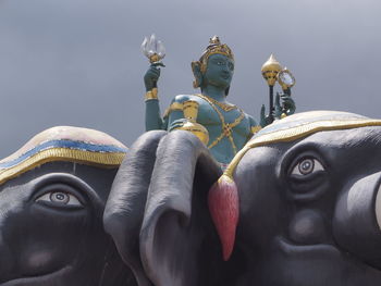 Close-up of buddha statue against sky