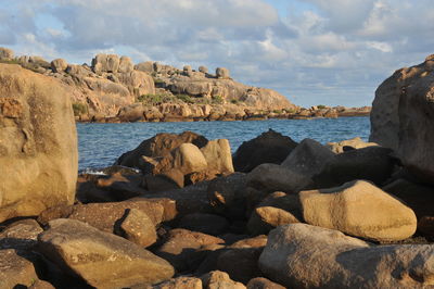 Rocks on sea shore against sky