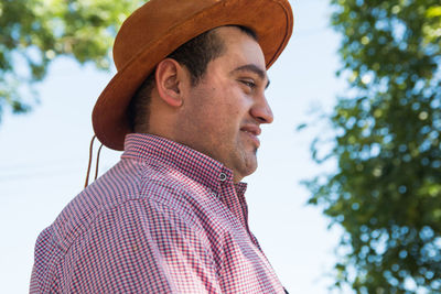 Low angle portrait of man wearing hat looking away