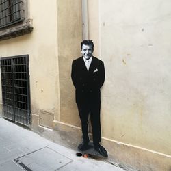 Portrait of man standing against wall