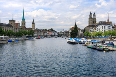 Boats at dock in river limmat of zurich. view of historic city with famous places