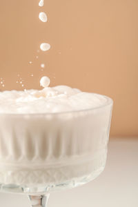 Milk pours into a beautiful crystal glass and splashes around.