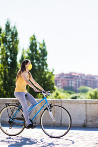 Young woman riding bicycle on street