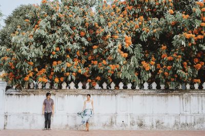 Rear view of people walking on flowering plants