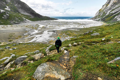 Rear view of man on mountain against sky