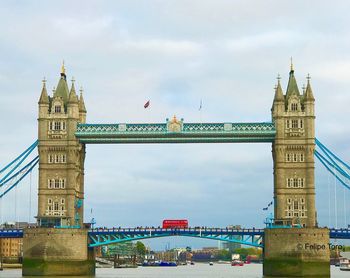 View of tower bridge over river against cloudy sky