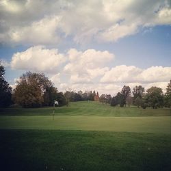 Scenic view of grassy field against cloudy sky