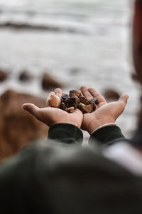 Close-up of hand holding rock in sea