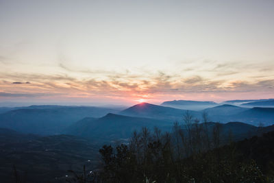 Scenic view of silhouette mountains against sky at sunset