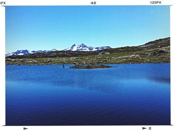 Scenic view of calm lake against clear blue sky