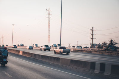 Cars on road against sky in city