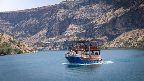 A passenger ship dives in the middle of the lake surrounded by mountains