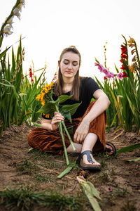 Portrait of woman sitting on plant