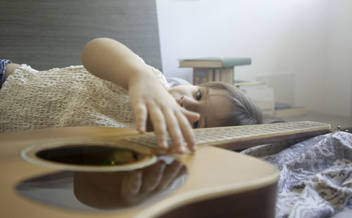 Midsection of woman lying on bed at home