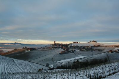 Scenic view of snow covered landscape against cloudy sky during sunset