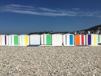 Multi colored chairs on beach against blue sky