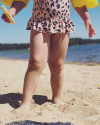 Low section of woman standing on beach