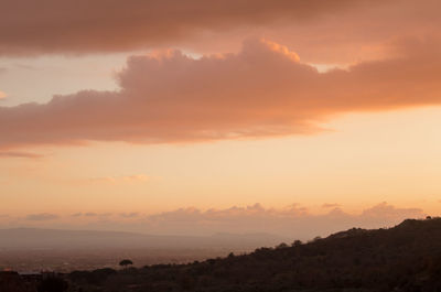 Scenic view of silhouette mountains against orange sky