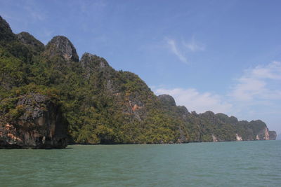 Scenic view of sea by cliff against sky
