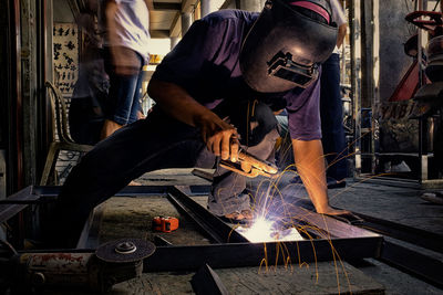 Man welding metal at workshop