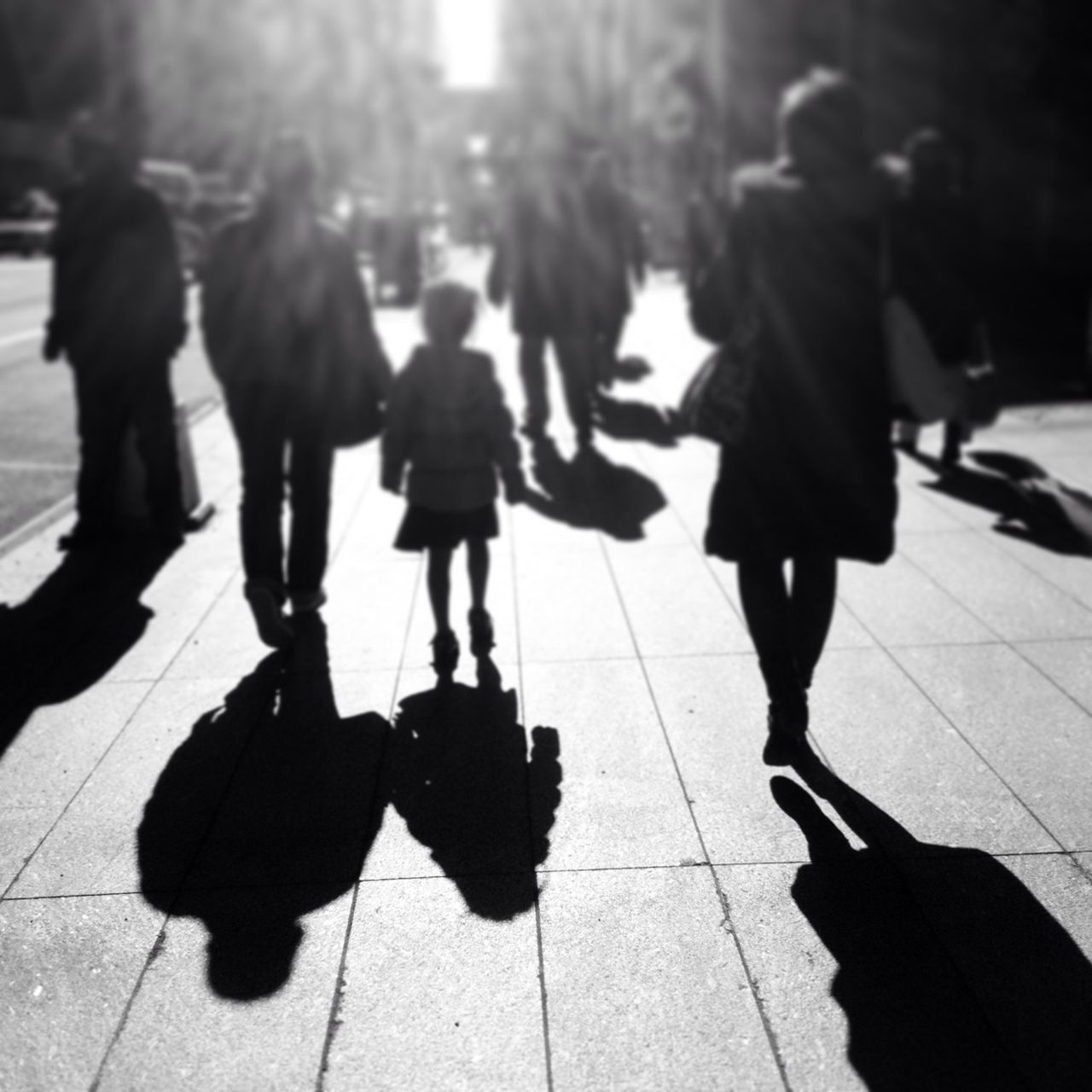 walking, men, shadow, lifestyles, street, person, city life, leisure activity, sunlight, rear view, city, full length, silhouette, sidewalk, togetherness, on the move, day, outdoors