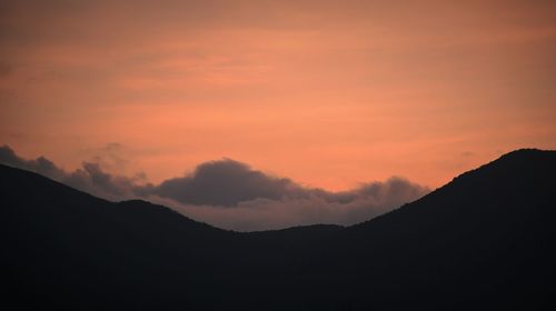 Scenic view of silhouette mountains against sky at sunset