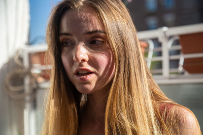 Close-up of young woman with blond hair looking away