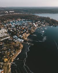 High angle view of cityscape by sea against sky