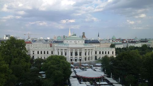 Buildings in city against cloudy sky