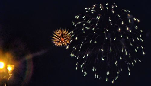 Low angle view of firework display at night