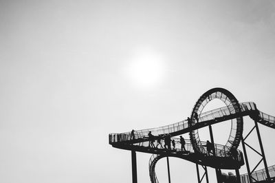 Low angle view of silhouette people on tiger and turtle - magic mountain against sky