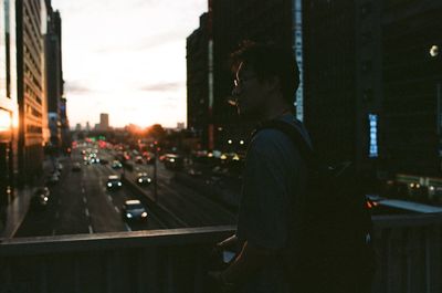 Side view of woman standing in city at night