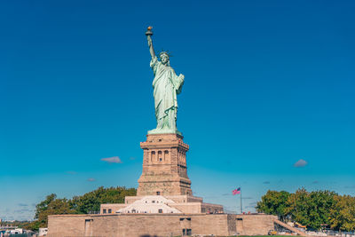 Low angle view of statue of liberty against clear blue sky