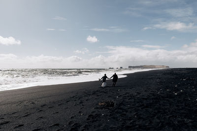 People on beach against sky