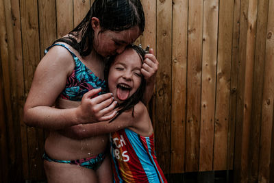 Girls hugging and being silly in outdoor shower