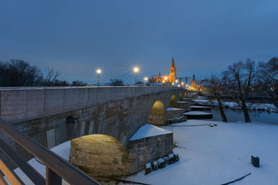 Illuminated bridge against sky during winter