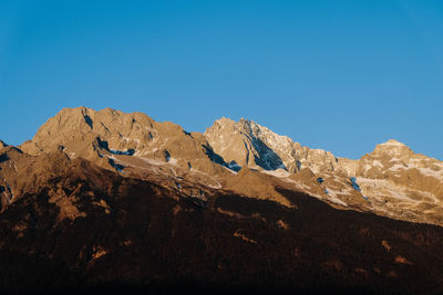 Low angle view of mountains against clear blue sky