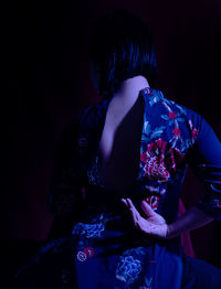 Rear view of woman standing in darkroom