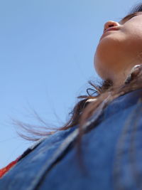 Low angle view of mid adult woman against clear sky