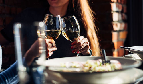 Two girls are drinking white wine in a bar