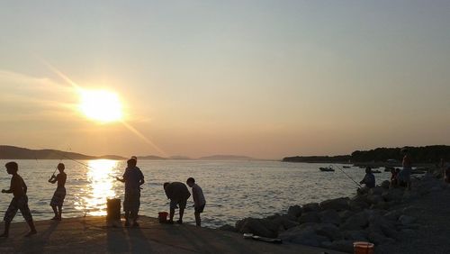 Silhouette of people at beach during sunset