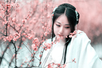 Young woman against cherry tree