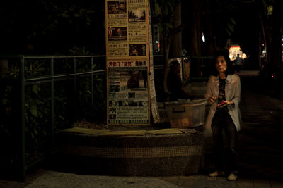 Man holding umbrella standing at night