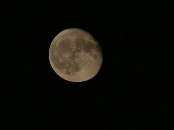 Low angle view of full moon against clear sky at night