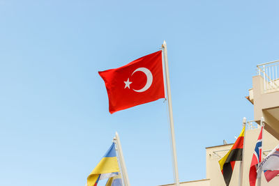 Low angle view of flag flags against blue sky