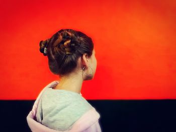 Rear view of woman standing against red background