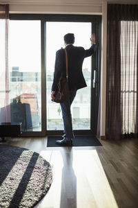 Businessman looking through window in hotel room